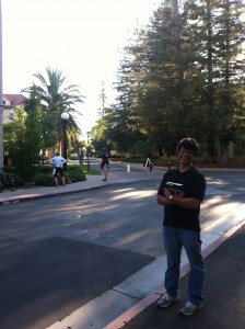 Photo of George Jahad on the campus of Stanford University in July 2013 holding a copy of If you see roadkill, think opera