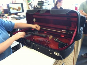 Alicia placing the mystery viola in a house case while it is held for evaluation at Lashof Violins.