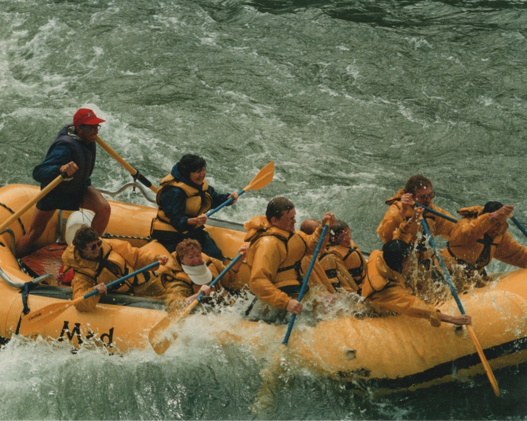 Photo of Stephan Alexander Parker guiding a yellow raft with 7 paddlers and two additional passengers through whitewater on the Snake River.