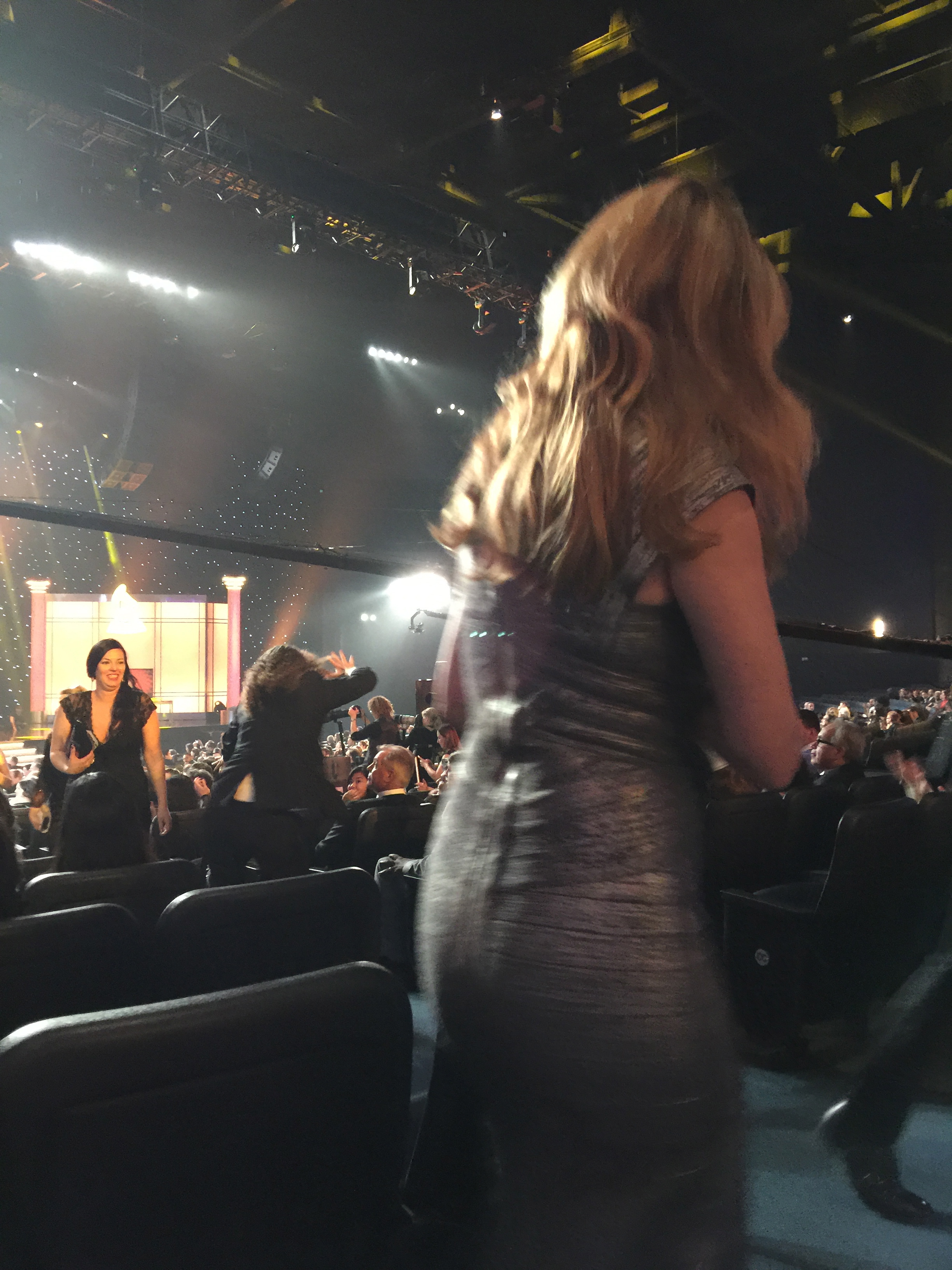 Photo of Jane Seymour in foreground as Weird Al Yankovich runs down the aisle to the stage in the background