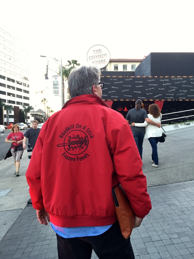 Photo showing Parker's back; he is wearing a red jacket with the Roadkill On A Stick Frozen Foods logo on the back