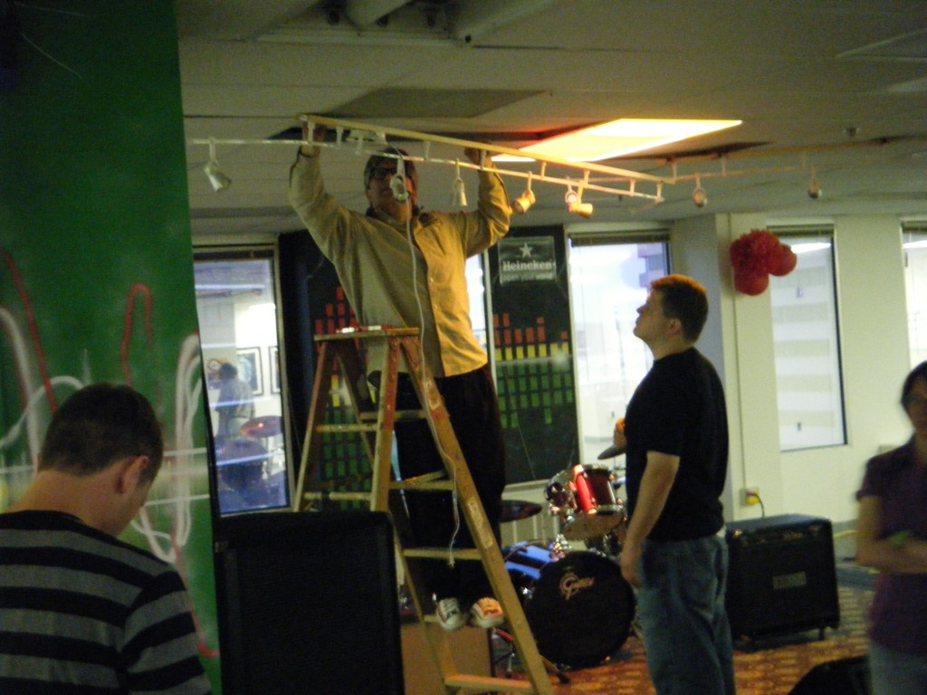 Photo of a man on a ladder hanging lights