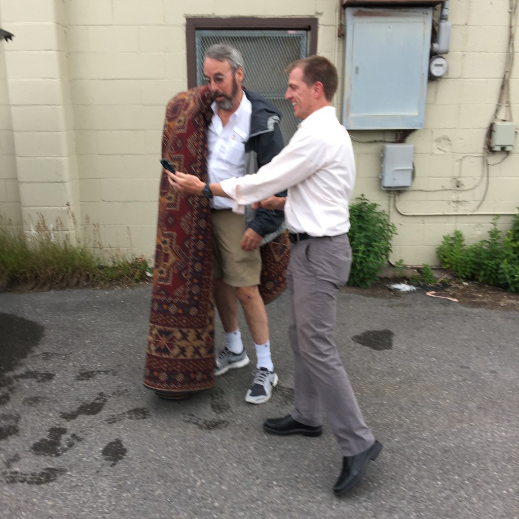 Photo of two men with a rug