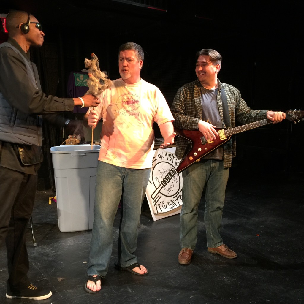 Photo of Marvin handing a roadkill on a stick to Stephan as Dave looks on