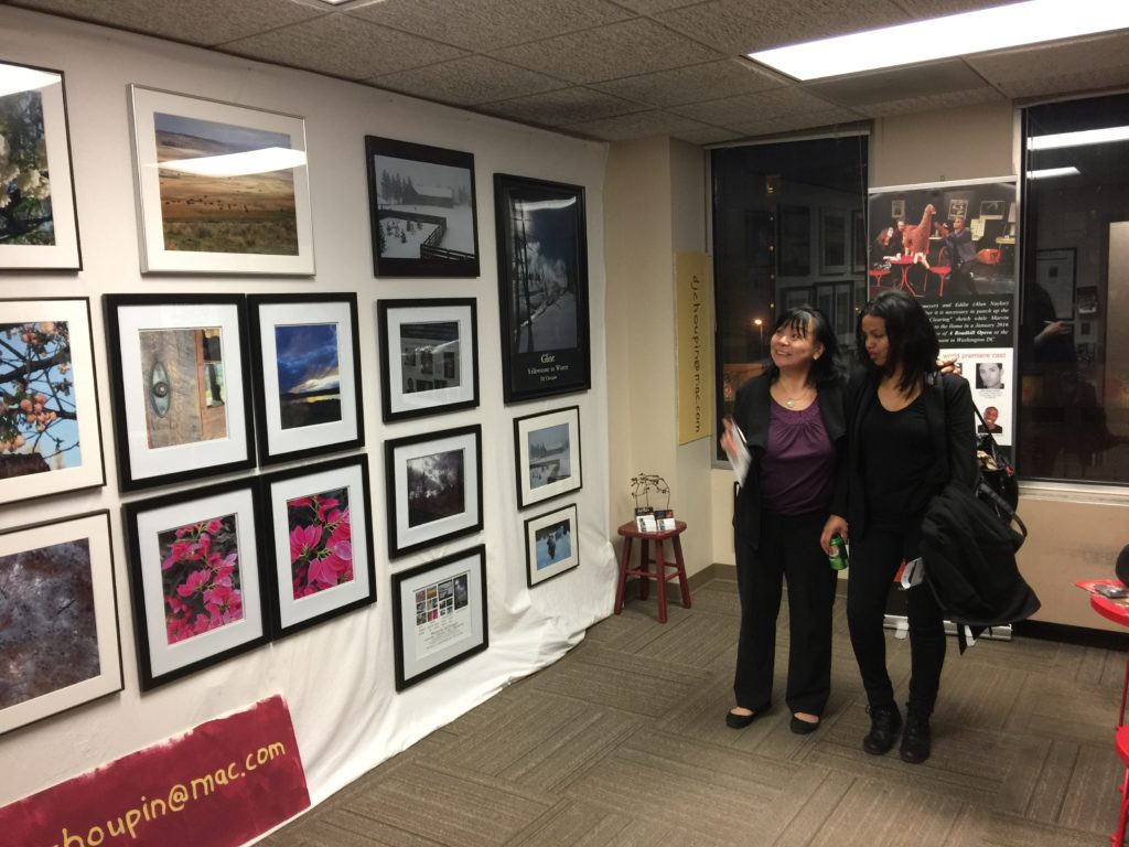 Photo of 2 women admiring CJ Choupin's photographs