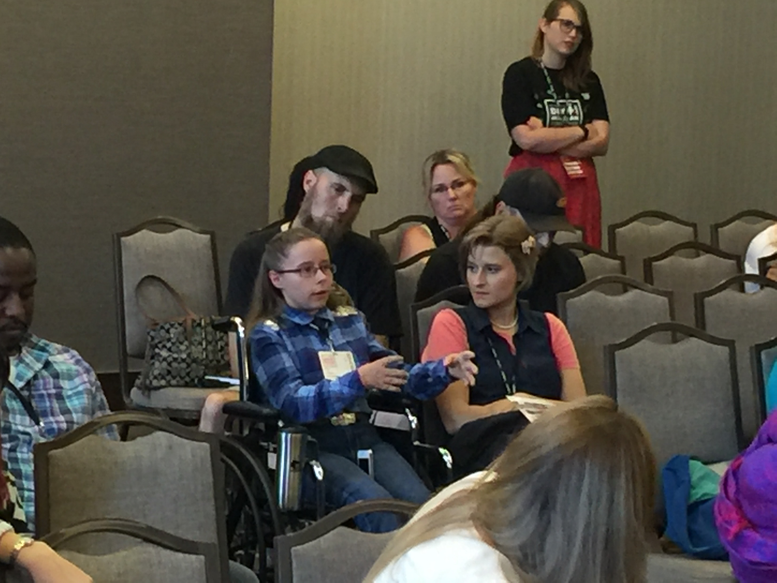 Photo of a woman in the audience holding a microphone and describing her merchandise strategy