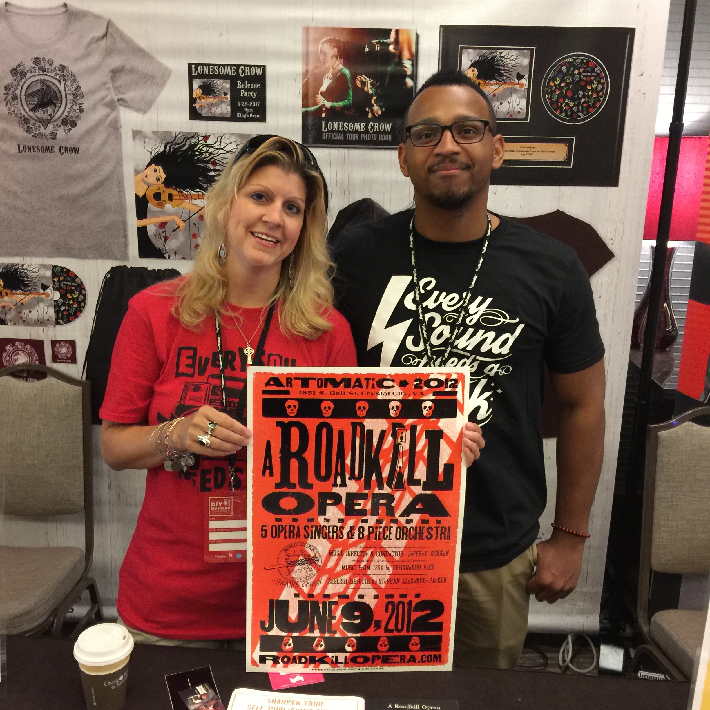 Photo of Michelle Borek and Josh Larkins of Disc Makers (AVL Digital Group) with A Roadkill Opera poster at the CD Baby DIY Musicians Conference 2017