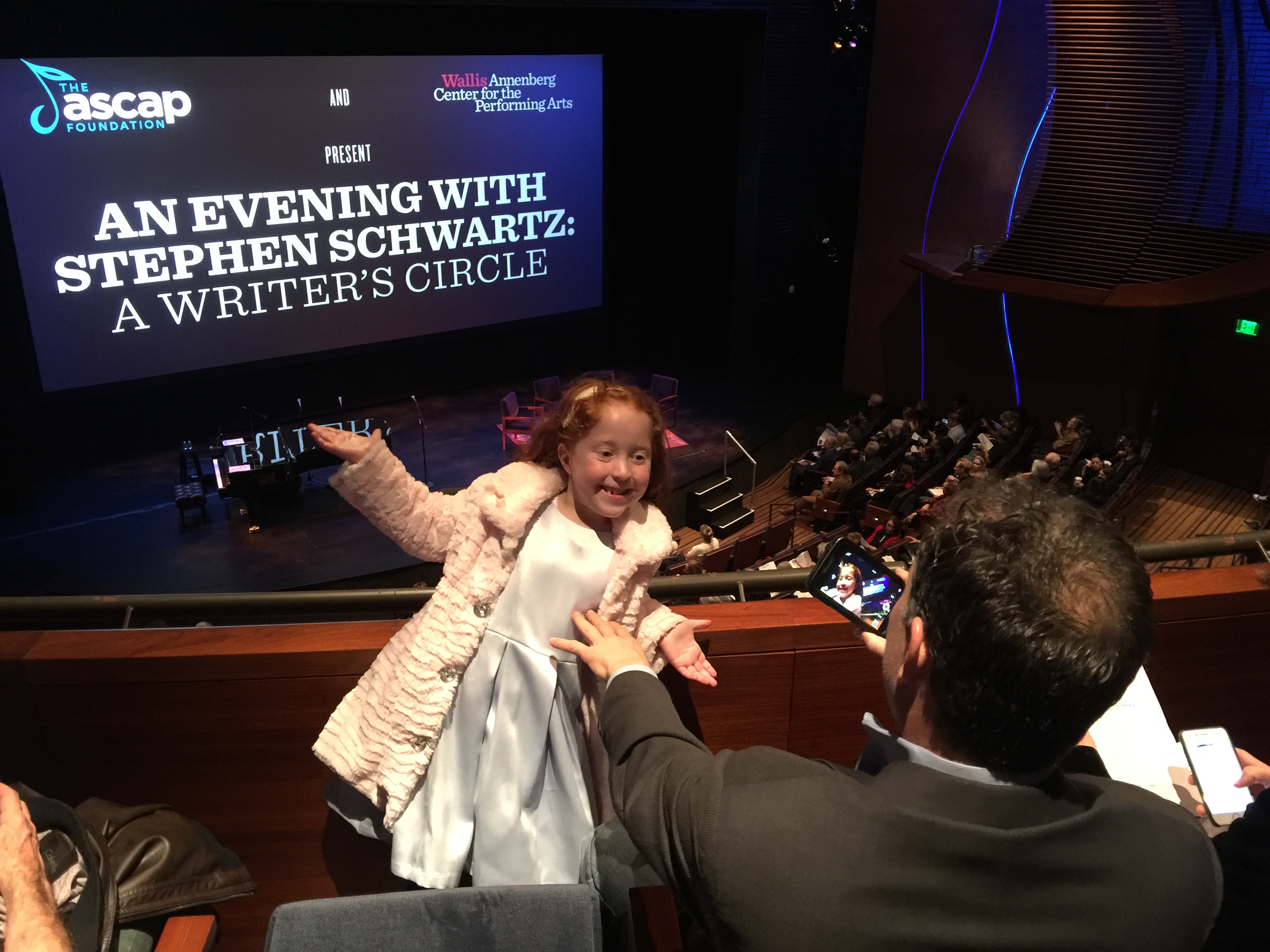 Photo of an excited redheaded 6 year old girl and her proud father, viewing the stage from the balcony, at An Evening With Stephen Schwartz: A Writer's Circle at the Wallis Theatre