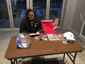 Photo of Clarence Davis at the check-in table for Artomatic 2016, reading the piano/vocal score for A Roadkill Opera